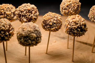 Candy bar of chocolate candy pops on sticks on wooden plate