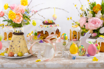 Wall Mural - Festive Easter table setting. Easter cake, Easter Eggs, Flower arrangements and home decorations for holiday.