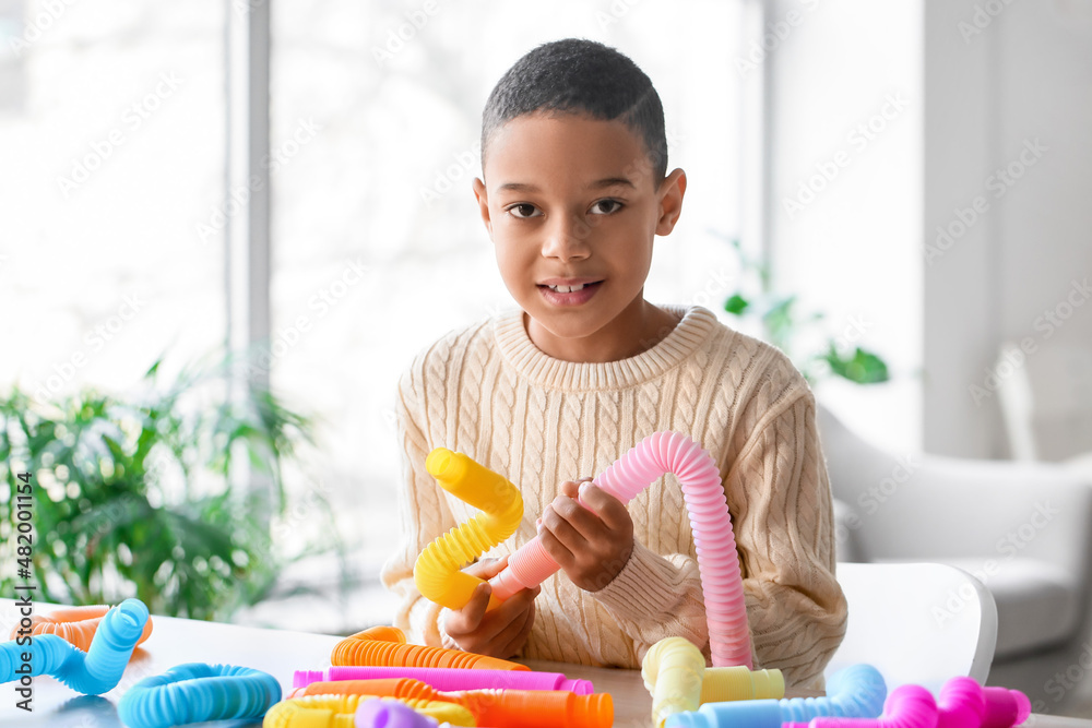 Little African-American boy playing with Pop Tubes at home