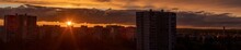 Sunset In The City Of Moscow, The Sun Sets Behind Residential Buildings, Beautiful Red Clouds