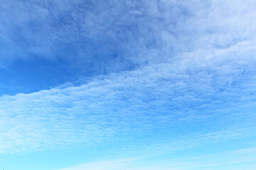 white cirrus clouds against a bright blue sky