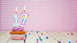 Muffin with cream and number 17 for a birthday on a pink background, copy space, holiday background. Happy birthday greetings for seventeen years old.