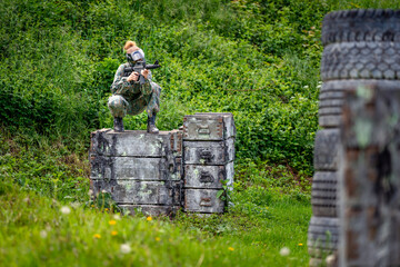 Wall Mural - young woman in action while playing paintball