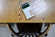 An Old Calculator Lies On A Vintage Wooden Table. Workplace Of The Times Of The USSR