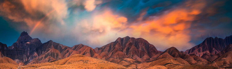 Fantastic landscape with mountain range and epic orange sunset sky