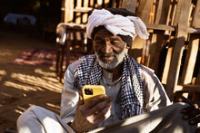 Senior Ethnic Man With Smartphone On Street