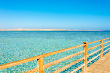 Wall Mural - wooden pier against blue sky and turquoise sea on a sunny day in egypt, sahl hasheesh