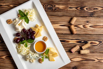 Wall Mural - Cheese plate with homey and grapes italian food