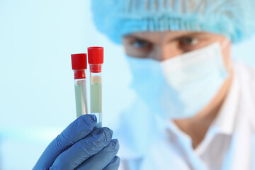 Poster - Scientist working with samples on light blue background, closeup. Medical research