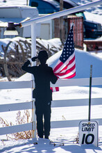 Black Wooden Shape Of A Man Holding The USA Flag