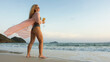 © ivandanru - Woman walks on sunset on beach against background of sea. Girl i