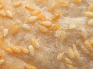 Poster - Sesame seeds on a golden brown crust of bread as a background.