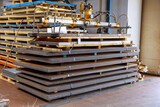Fototapeta  - Stack of sheet metal of different thickness stacked on top of each other. Suction cups for lifting sheet metal.