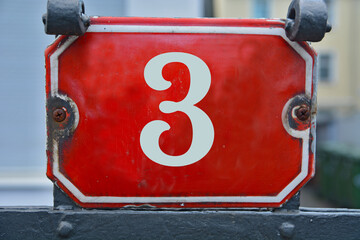 Wall Mural - A red number plaque, showing the number three (number 3)