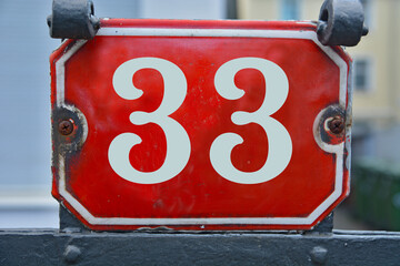 A red number plaque, showing the number thirty-three, 33