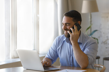 happy busy professional man talking on telephone, making call to client, giving consultation, typing