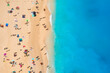 People relaxing on the beach during their vacation. Blue sea water. Summer landscape from drone. Aerial landscape.