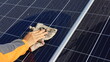 © kanin - Hand cleaning solar panels. A woman's hands use a towel to wipe dirty and nasty solar panels with dust and bird droppings outdoors with copy space. Selective focus