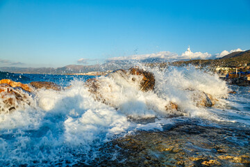 Beautiful Sea Landscape with Waves Breaking on a Sandy and Rocky Beach. Waves on Background. Summer time in Rhodes, Greece. rocks on the coast of blue sea on a sunny summer day