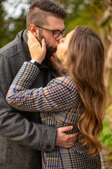 Wall Mural - White young european married couple portrait kissing outside