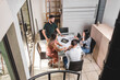 © STOCKEROcr - Vista superior de un Grupo de profesionales analizando planos constructivos e imágenes de un proyecto.