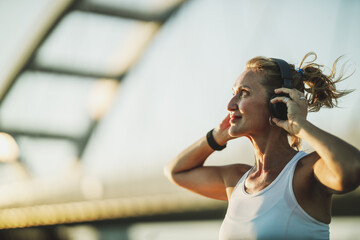 Wall Mural - Woman Listening Music And And Preparing To Training Near The River