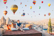 © travnikovstudio - Happy young man watching hot air balloons in Cappadocia, Turkey