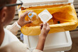 © Seventyfour - Top view close up of African-American boy putting plastic in recycling bins at home, copy space