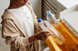 © Seventyfour - Cropped shot of African-American boy putting plastic in recycling bins at home, copy space