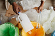 © Seventyfour - Top view close up of African-American father and son putting plastic in recycling bins at home, copy space