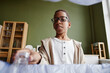 © Seventyfour - Low angle of boy sorting household waste at home and putting plastic bottle in recycling bin, copy space