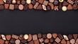 chocolate candies on blackboard background, various pralines and truffles with empty space