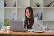 © Songsak C - Smiling young Asian businesswoman using a computer at home office workplace