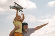 © Volodymyr - Excited child boy and grandfather having fun with plane outdoor on sky background with copy space. Child dreams of flying, happy childhood with grand dad.