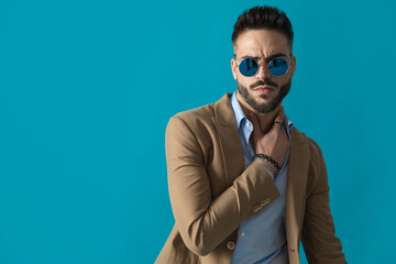 portrait of sexy man with retro sunglasses holding hand on neck