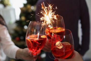 Wall Mural - People are holding cocktails with sparklers, close-up