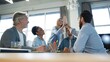 © opolja - Two cheerful young business people giving high-five while their colleagues looking at them and smiling