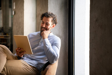 Wall Mural - Portrait of successful handsome business man using digital tablet in office