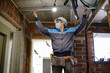 © Westend61 - Worker measuring breadth with steel rod at construction site