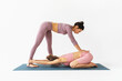 A woman teacher of yoga therapy performs traction traction of the spine for her student, sitting in a child's position, balasana, improving posture