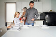 © Retamosa - Family consisting of father, mother and daughter setting the table to eat in the kitchen.
