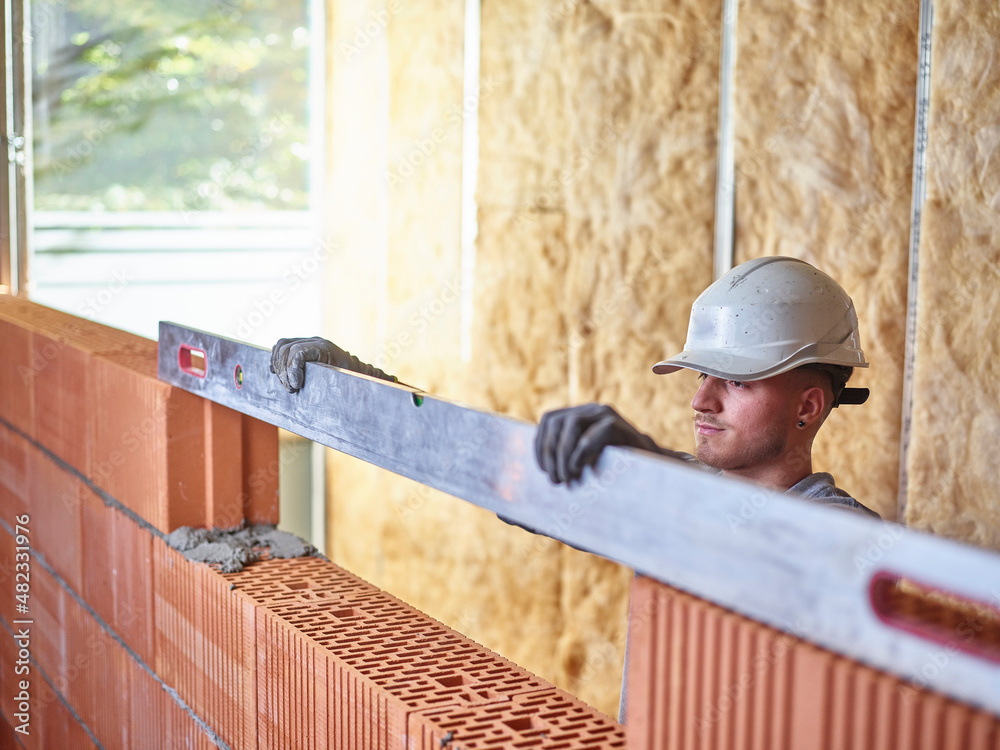 Bricklayers Level Concentrated bricklayer using spirit level to measure bricks at ...