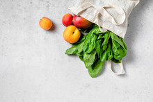 Studio Shot Of Reusable Bag Filled Ripe Peaches Andspinach