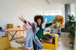 © Westend61 - Playful young Afro woman with clothes on her having fun at home