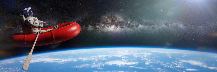 Wall Mural - astronaut in rubber boat in orbit of planet earth, background banner