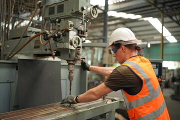 Portrait of Professional Heavy Industry Engineer / Worker Wearing Safety Uniform, Goggles and Hard Hat. In the Background Unfocused Large Industrial Factory