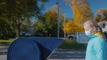A Child Sends A Letter - Throws It Into A Blue Mailbox On A Typical American Street