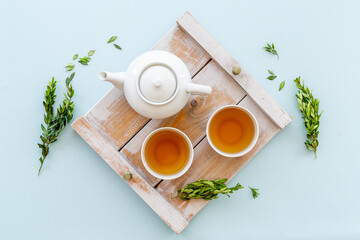 Asian food and drink set white teapot and black tea in two cups