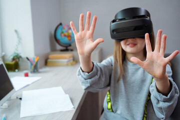 Wall Mural - schoolgirl using virtual reality simulator for studying. child is wearing virtual reality glasses si