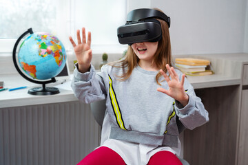 Wall Mural - schoolgirl is using virtual reality simulator headset for study. child is wearing virtual reality gl